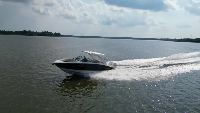 Slide: The Image of 2019 Regal 29 OBX boat cruising on a calm lake under a cloudy sky. - 5