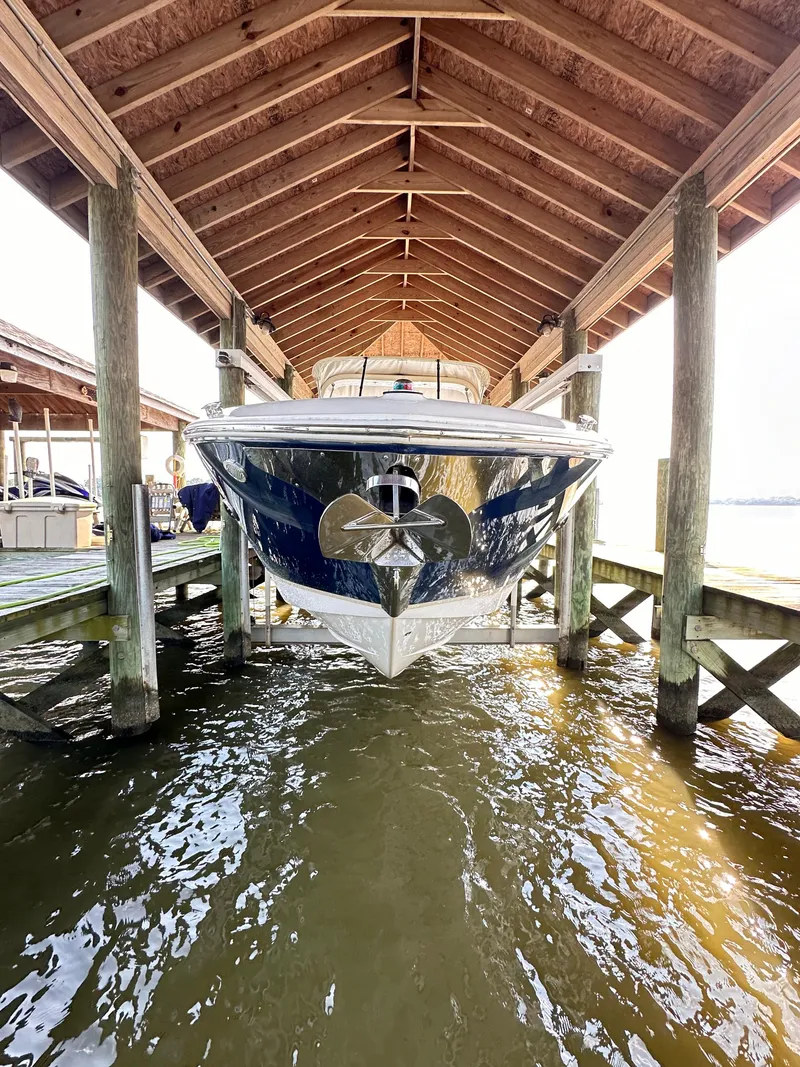 Slide: The Image of 2019 Regal 29 OBX boat docked under wooden shelter. - 7