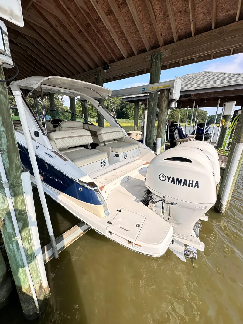 Slide: The Image of 2019 Regal 29 OBX boat with Yamaha outboard engines docked under a wooden shelter. - 8
