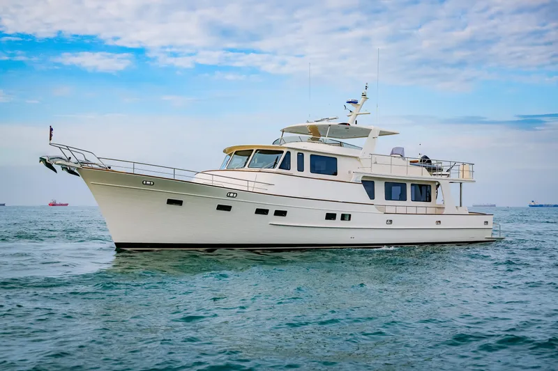 Slide: The Image of Luxury Fleming 85 yacht cruising on open water, 2027 model, under a partly cloudy sky. - 2