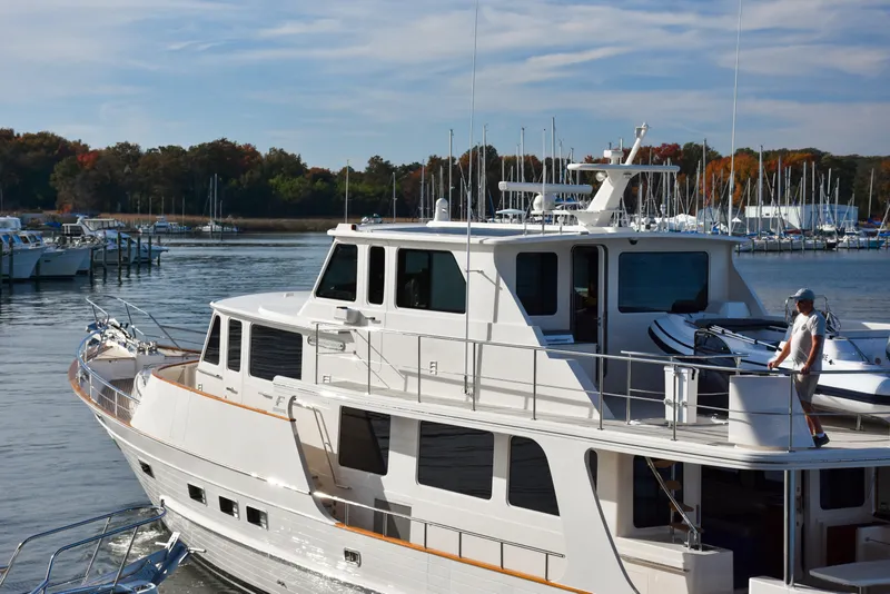 Slide: The Image of Luxurious 2027 Fleming 85 yacht docked in a serene marina setting. - 6