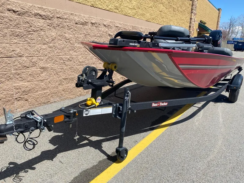 Slide: The Image of 2025 Tracker Bass Tracker Classic XL boat on trailer, parked beside a brick wall. - 2