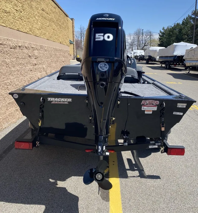Slide: The Image of 2025 Tracker Bass Tracker Classic XL boat with Mercury 50 engine, parked outdoors. - 2