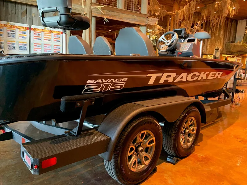 Slide: The Image of 2025 Tracker Savage 215 boat on trailer in rustic indoor setting. - 2