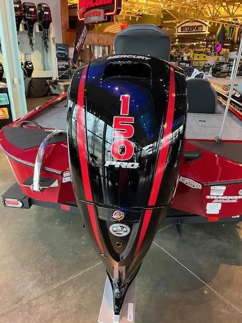 Slide: The Image of 2025 Tracker Savage 215 boat with a 150 Pro outboard motor, displayed indoors. - 3