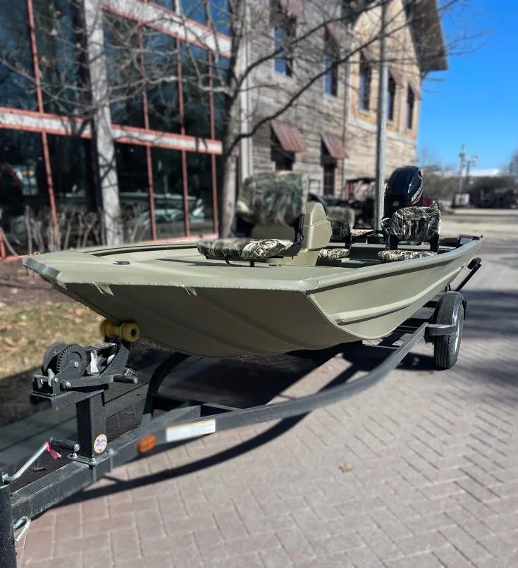 Slide: The Image of 2025 Tracker Grizzly 1754 SC boat on trailer, parked outdoors near buildings. - 3
