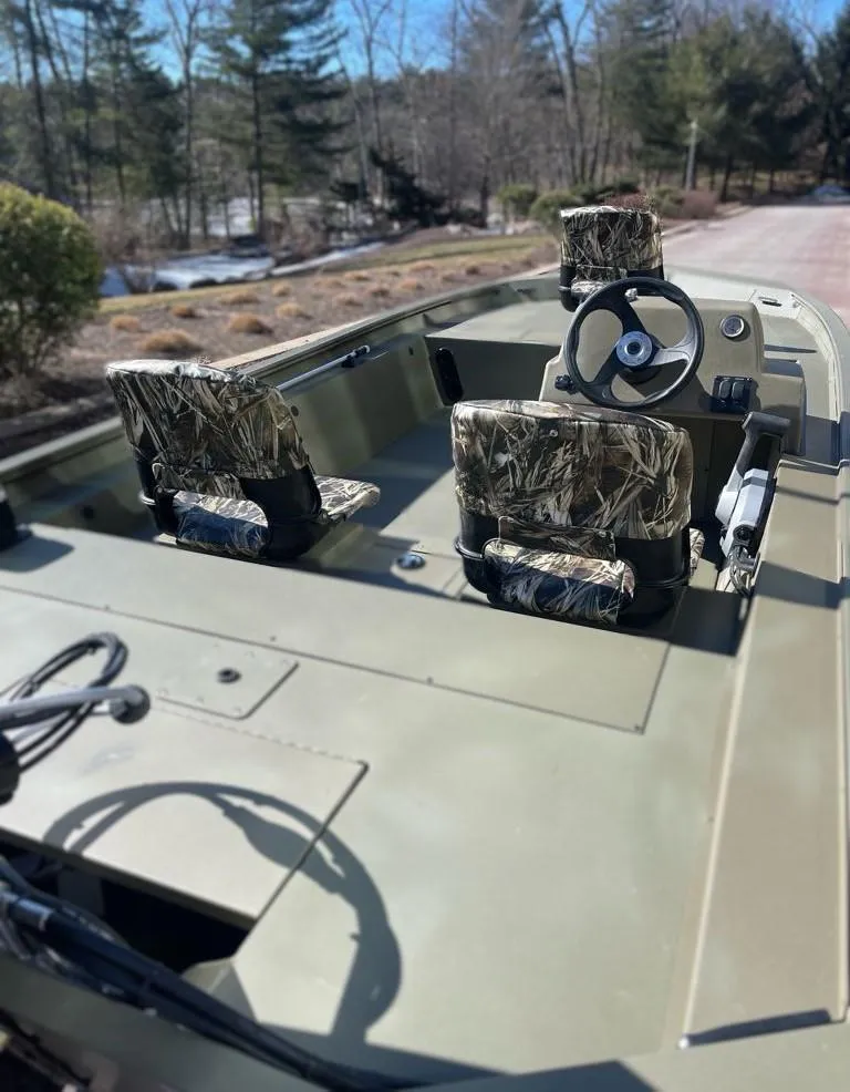 Slide: The Image of 2025 Tracker Grizzly 1754 SC boat with camo seats, steering wheel, and open deck. - 5