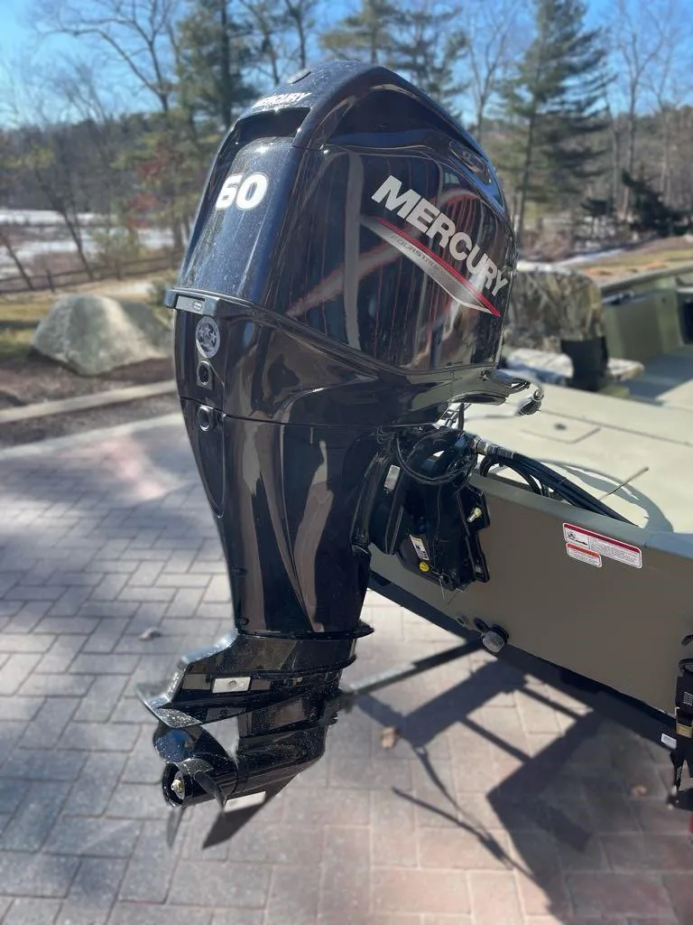 Slide: The Image of 2025 Tracker Grizzly 1754 SC with Mercury 60 outboard motor, parked outdoors. - 6