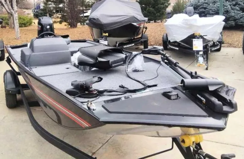 Slide: The Image of 2025 Tracker Bass Tracker Classic XL fishing boat on trailer, parked outdoors. - 2