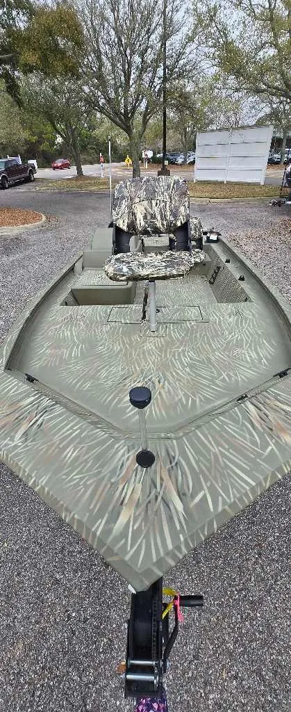 Slide: The Image of 2025 Tracker Grizzly 1754 SC boat with camouflage design, parked outdoors. - 3