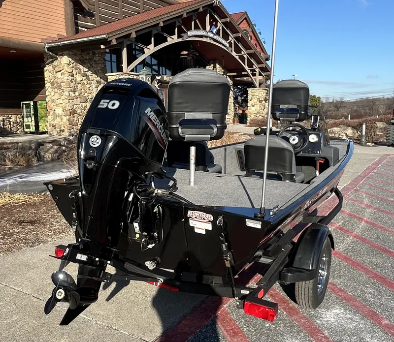 Slide: The Image of 2025 Tracker Bass Tracker Classic XL boat with Mercury engine, parked outdoors. - 5