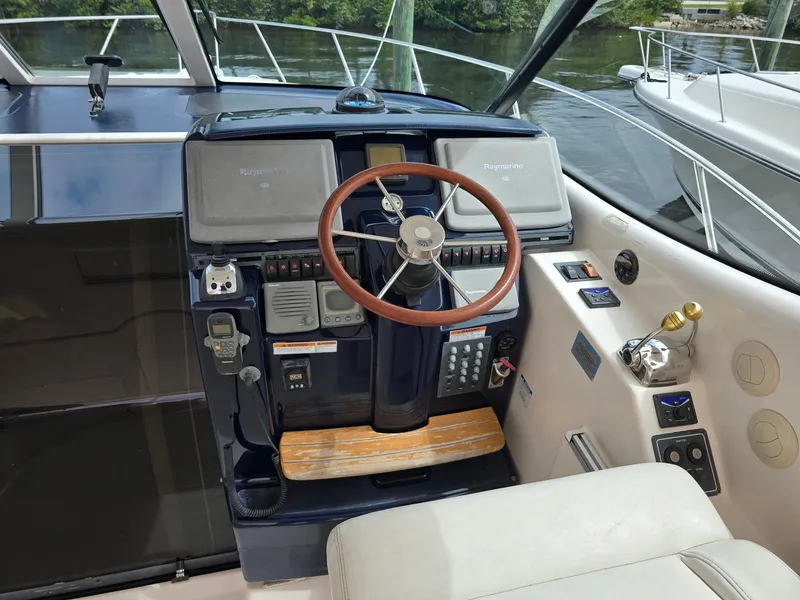 Slide: The Image of 2008 Tiara Yachts 3900 Sovran helm with wooden steering wheel and navigation controls. - 3