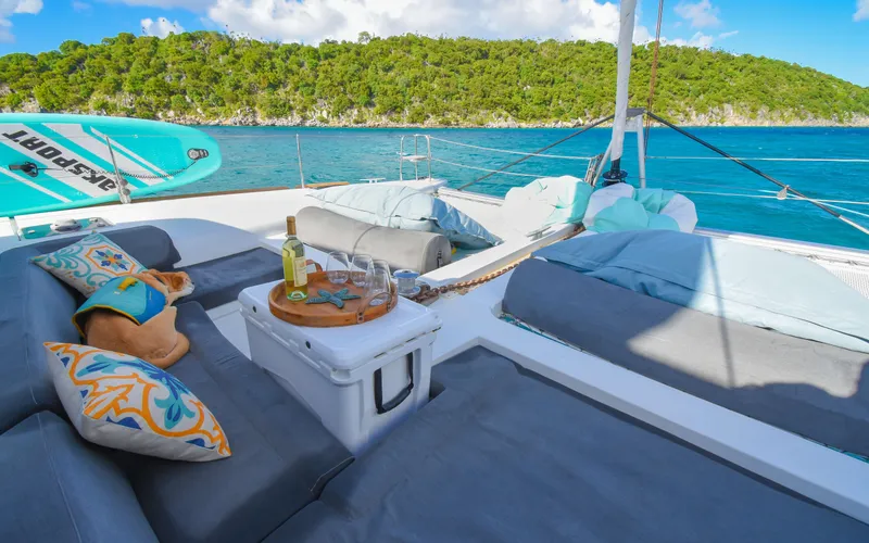 Slide: The Image of Luxurious Lagoon 450F catamaran deck with wine, cushions, and scenic ocean view. - 10