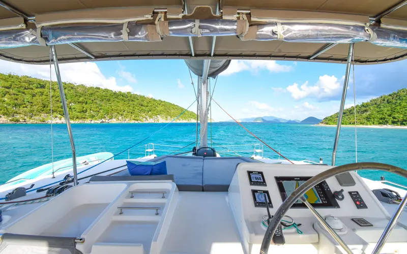 Slide: The Image of 2015 Lagoon 450F catamaran cockpit with scenic ocean view and lush green islands. - 11