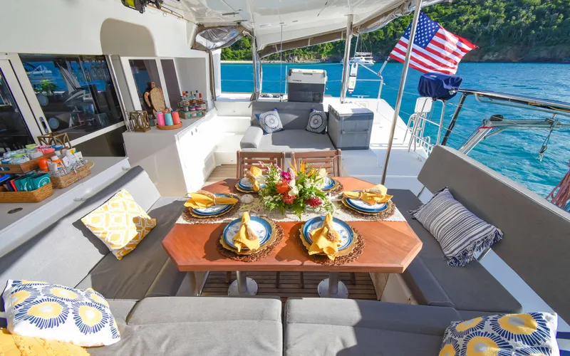 Slide: The Image of Luxurious 2015 Lagoon 450F yacht with elegant outdoor dining setup and scenic ocean view. - 27