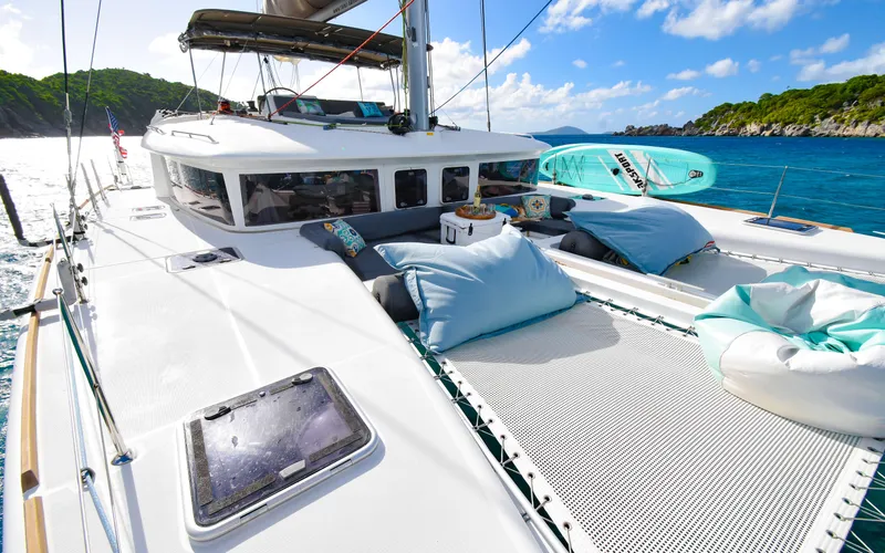 Slide: The Image of Luxurious 2015 Lagoon 450F catamaran with sunbathing area, sailing in clear blue waters. - 6