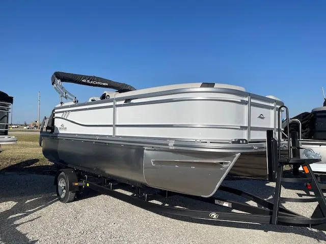 Slide: The Image of 2025 SunCatcher Select 20RC pontoon boat on trailer, under clear blue sky. - 0