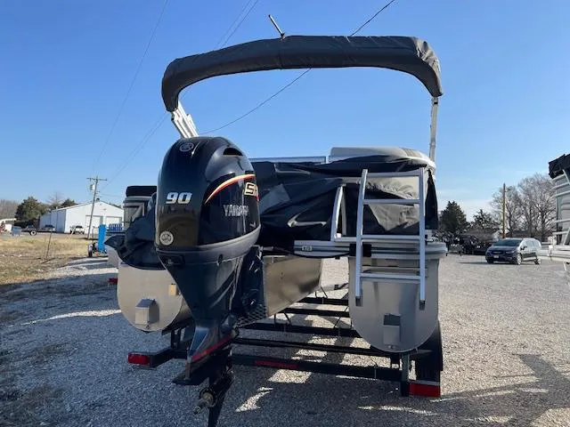 Slide: The Image of 2025 SunCatcher Select 20RC pontoon boat with Yamaha 90 engine, parked on gravel. - 6