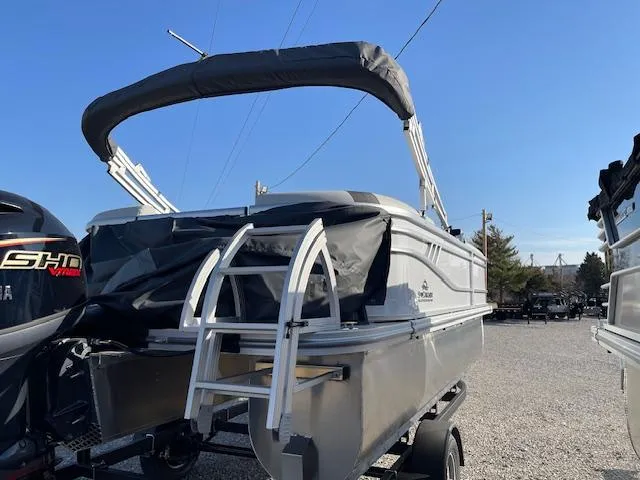 Slide: The Image of 2025 SunCatcher Select 20RC pontoon boat with canopy, parked on a trailer. - 7