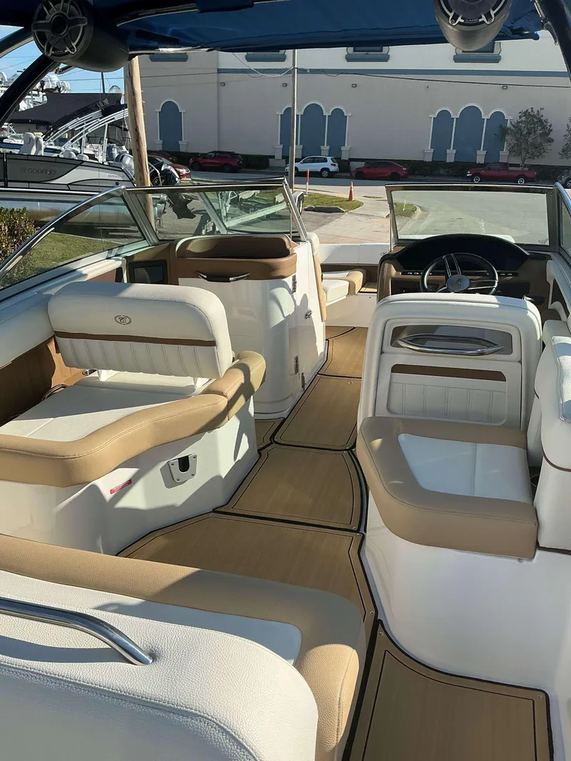 Slide: The Image of 2022 Cobalt 23 SC boat interior with tan and white seating, sleek design. - 11