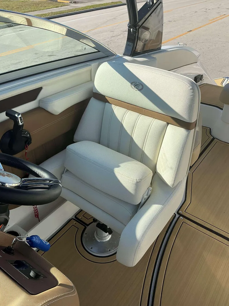 Slide: The Image of 2022 Cobalt 23 SC boat interior with white captain's seat and steering wheel. - 12