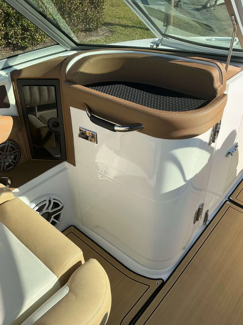 Slide: The Image of 2022 Cobalt 23 SC boat interior with tan and white seating, modern design. - 15