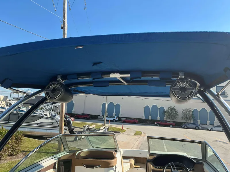Slide: The Image of 2022 Cobalt 23 SC boat interior with blue canopy and speakers. - 17