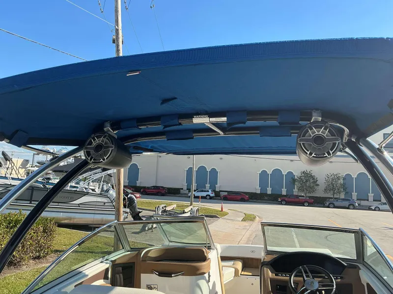 Slide: The Image of 2022 Cobalt 23 SC boat interior with blue canopy and speakers. - 22