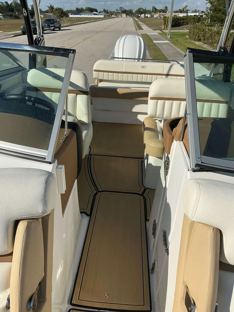 Slide: The Image of 2022 Cobalt 23 SC boat interior with beige seating and open windshield. - 9