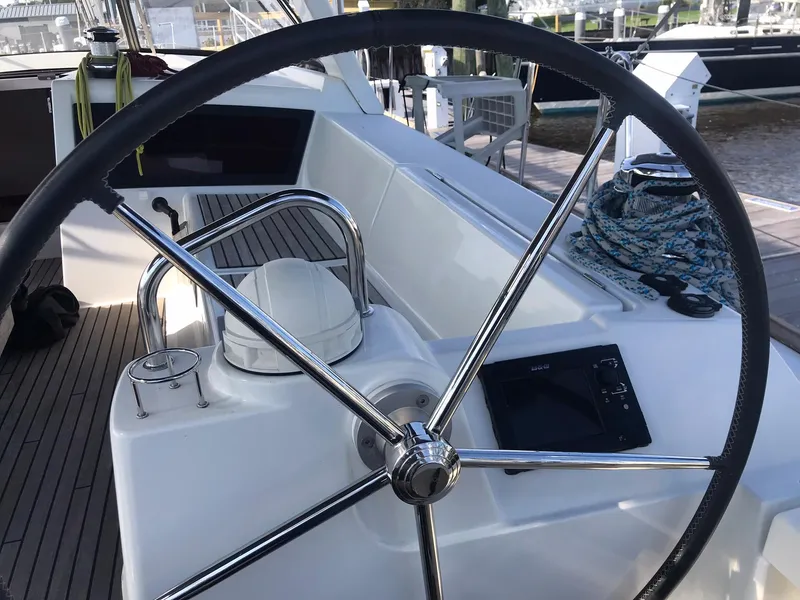 Slide: The Image of Steering wheel of 2014 Beneteau Oceanis 48 yacht, featuring sleek design and navigation equipment. - 16