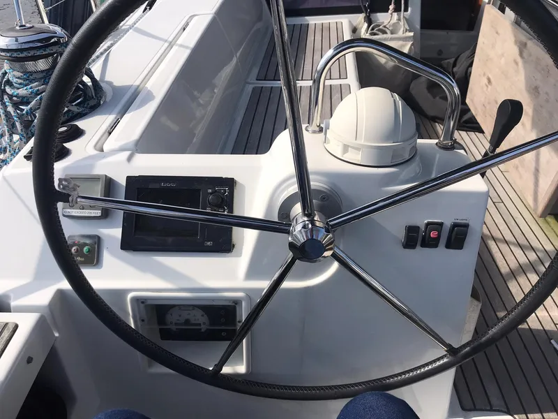Slide: The Image of Steering wheel of a 2014 Beneteau Oceanis 48 sailboat, featuring navigation controls. - 17