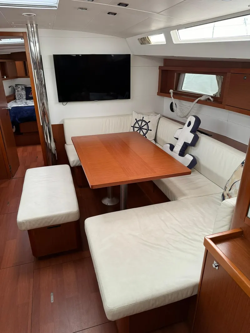 Slide: The Image of Interior of 2014 Beneteau Oceanis 48 yacht with cozy dining area and nautical decor. - 25