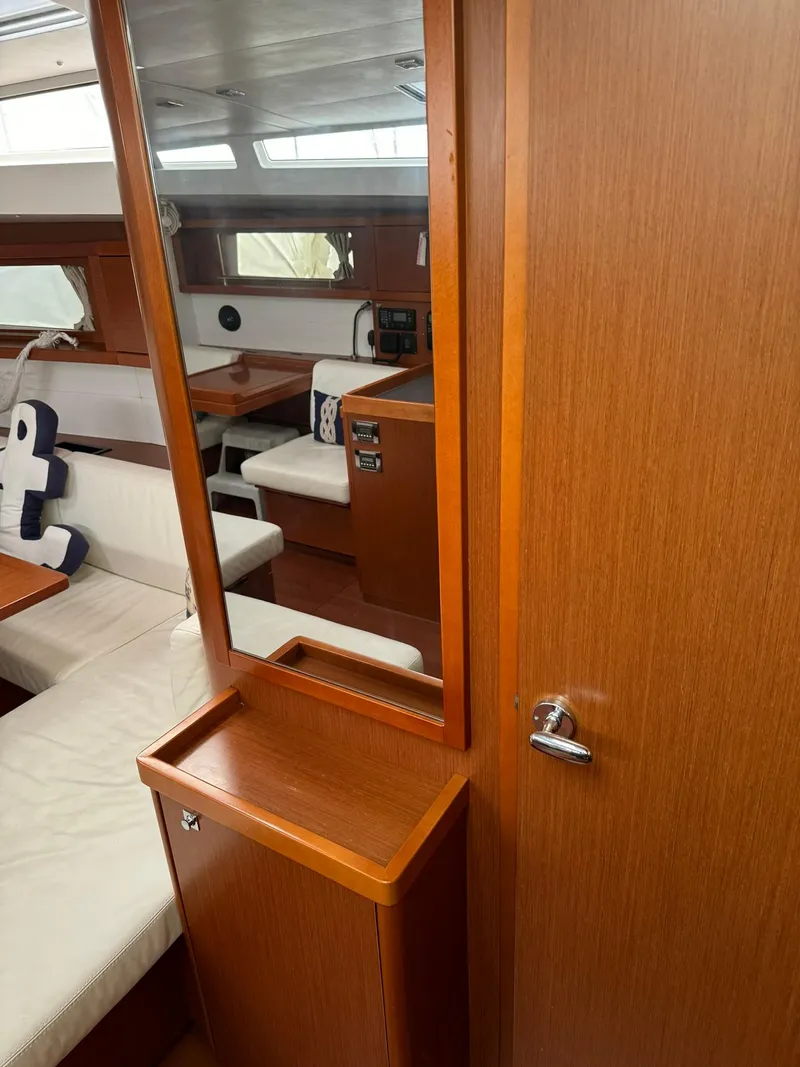 Slide: The Image of Interior of 2014 Beneteau Oceanis 48 yacht, featuring wood finishes and seating area. - 28