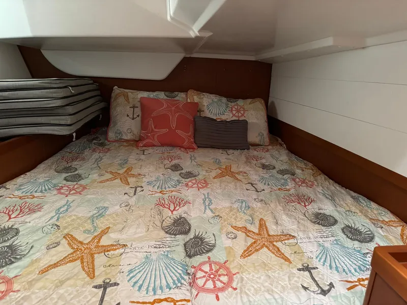 Slide: The Image of Cozy cabin bed in 2014 Beneteau Oceanis 48 with nautical-themed bedding. - 48