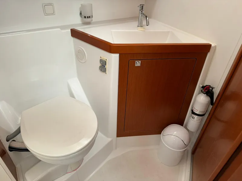Slide: The Image of Bathroom of 2014 Beneteau Oceanis 48 yacht with sink, toilet, and fire extinguisher. - 49