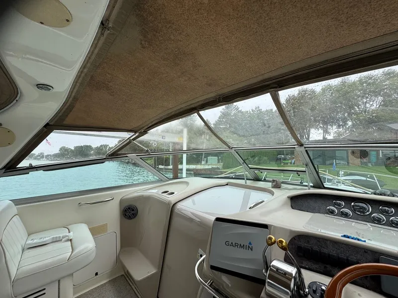 Slide: The Image of 1998 Sea Ray 330 Sundancer helm with Garmin navigation, overlooking serene waterfront. - 11