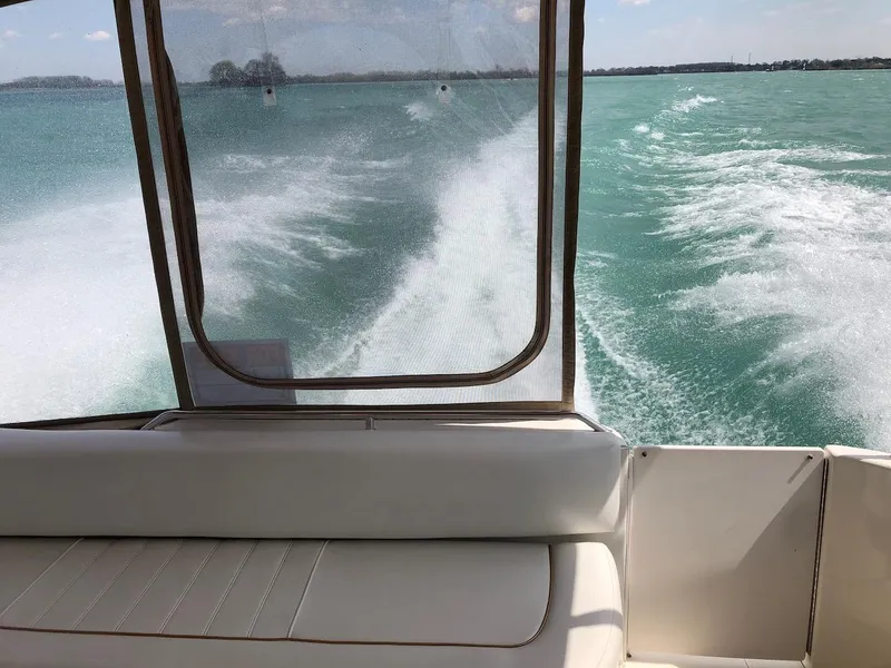 Slide: The Image of 1998 Sea Ray 330 Sundancer cruising on turquoise waters, view from the boat's interior. - 20