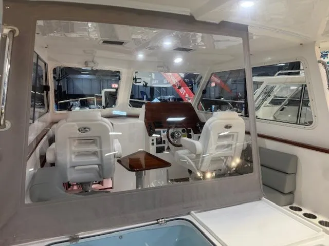 Slide: The Image of 2025 NorthCoast 285 HT boat interior with helm, seating, and modern dashboard. - 13