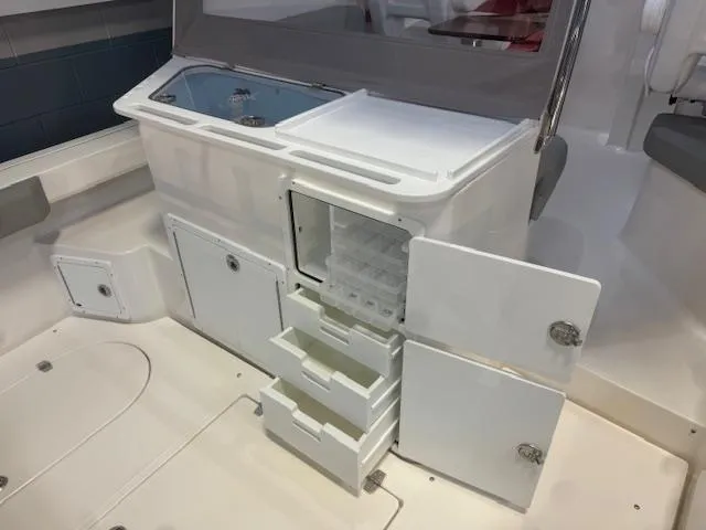 Slide: The Image of 2025 NorthCoast 285 HT boat interior with open storage compartments and drawers. - 15