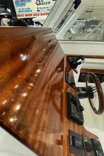 Slide: The Image of 2025 NorthCoast 285 HT boat dashboard with polished wood finish and modern controls. - 16