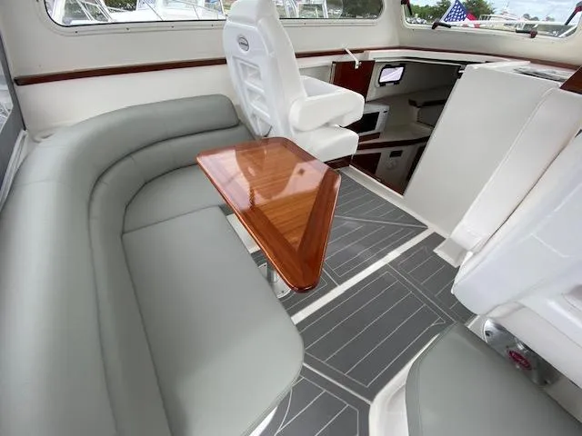 Slide: The Image of 2025 NorthCoast 285 HT boat interior with gray seating and wooden table. - 3