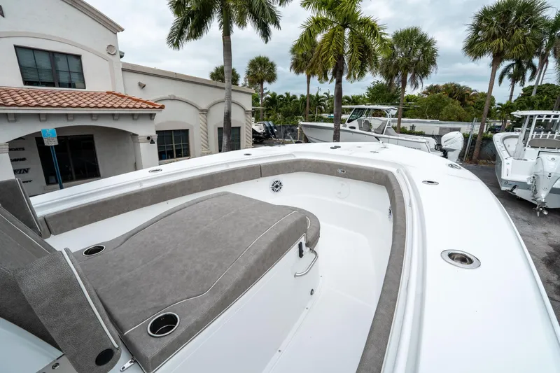Slide: The Image of 2025 Sea Hunt Gamefish 28 CB boat, featuring spacious deck and seating, surrounded by palm trees. - 35