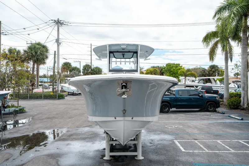 Slide: The Image of 2025 Sea Hunt Gamefish 28 CB boat in a parking lot, surrounded by palm trees. - 7