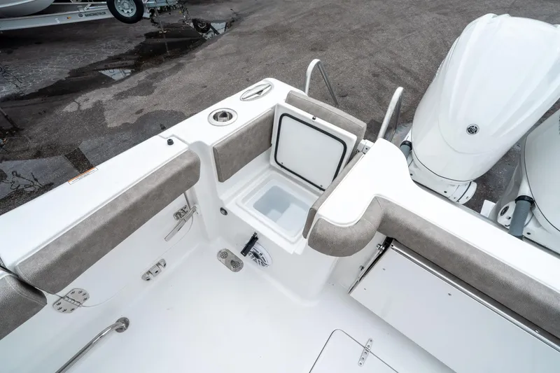 Slide: The Image of 2025 Sea Hunt Gamefish 28 CB boat interior with open storage compartment and dual engines. - 15