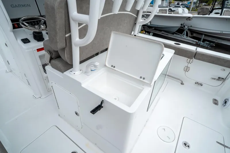 Slide: The Image of 2025 Sea Hunt Gamefish 28 CB interior with open storage compartment and Garmin equipment. - 17