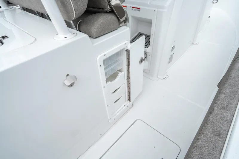 Slide: The Image of 2025 Sea Hunt Gamefish 28 CB interior storage compartment with open door and seating. - 19