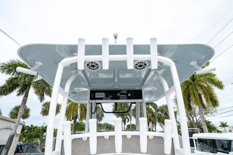 Slide: The Image of 2025 Sea Hunt Gamefish 28 CB boat with rod holders and speakers, surrounded by palm trees. - 22