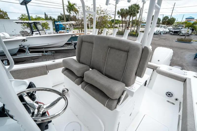 Slide: The Image of 2025 Sea Hunt Gamefish 28 CB boat interior with cushioned seating and steering wheel. - 31
