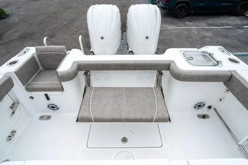 Slide: The Image of 2025 Sea Hunt Gamefish 28 CB boat interior with cushioned seating and dual engines. - 13
