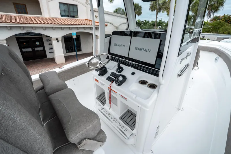 Slide: The Image of 2025 Sea Hunt Gamefish 28 CB boat cockpit with Garmin displays and comfortable seating. - 26